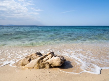 Rocks on the sandy beach near the campsite of Stara Baska