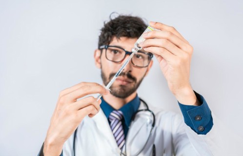 Doctor drawing medicine from a vial isolated. Young doctor drawing medicine from a vial with copy space. Concept of doctor with disease antidote