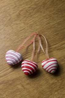 3 pendants in heart shape on wooden plate for decoration