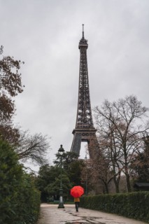 Women with red umbrella in front of the Eifel Tower