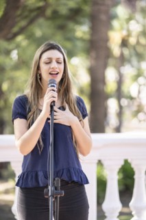 Young blonde woman singing in the street. Singer performing in the street