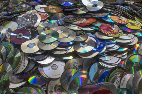 Old CD's collected for recycling in a container