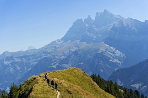 Hikers on the Arrete de Berroi hiking trail with a view of the Dents du Midi mountain range