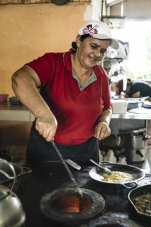 Woman cooks on a wood stove. Typical Costa Rican Restaurant. Local people and traditional food