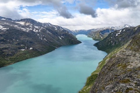 View of Lake Gjende and snowy mountains