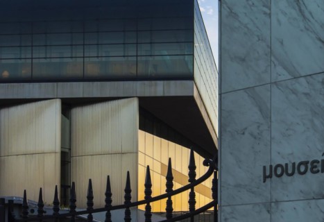 Facade of Acropolis museum facing Acropolis reserch center mirroring the sunset