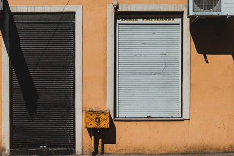 Orange wall with closed shop blinds