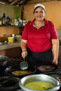 Latin mature woman looking at the camera while cooking a typical Costa Rican meal