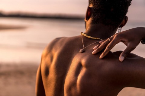 Back of black ethnic man on summer vacation by the sea feeling free