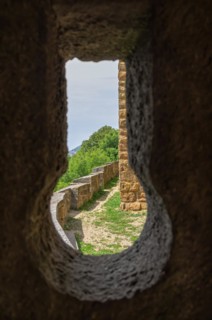 View through a keyhole in the castle walls onto parts of the outer castle complex