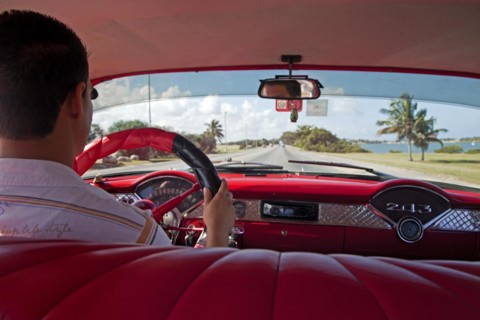 Cuban taxi driver and interior of old 1950s vintage American car