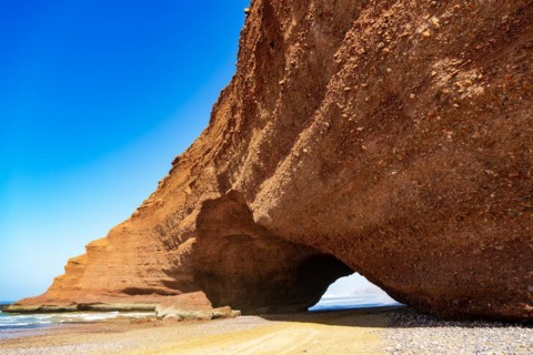 Natural rock coastal arch erosional landform on beach