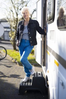 Subject: Pensioner in front of her caravan.