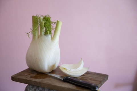 Fresh fennel bulb with knife on a wooden board