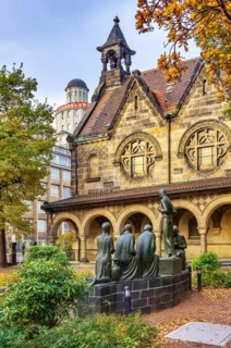 Court of honour with arcades and group sculpture of the Consoling Christ by Selmar Werner. The church