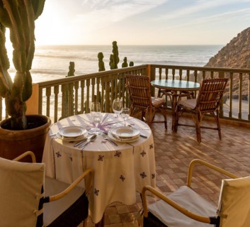 Table set for dinner for two hotel balcony overlooking Atlantic Ocean