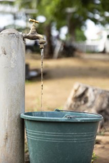Water. Water bucket and running tap in Lome