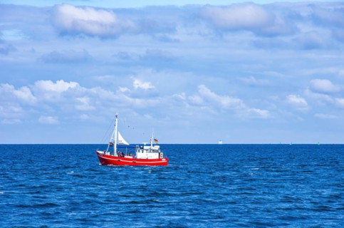 The fishing vessel PASEWALK leaves the harbour entrance with passengers and with a hoisted pirate flag towards the open sea