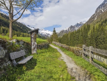 Wayside shrine with bench in front of mountain scenery
