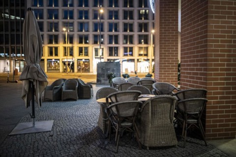 Unused furniture standing in front of a cafe at Potsdamer Platz in Berlin in the evening