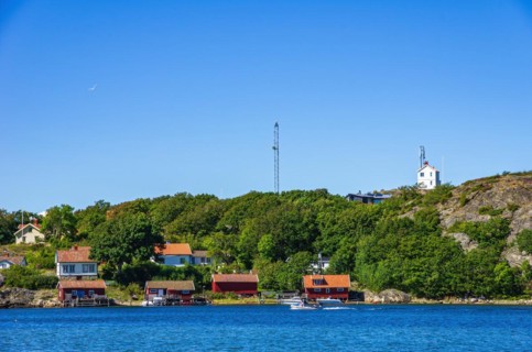 Picturesque coastal landscape with cottages and boat sheds