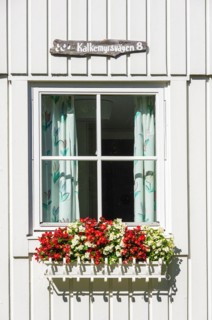 Wooden holiday home with flower box by the window in the picturesque village of Nordkoster