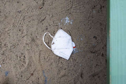 A discarded mouth-nose protection lies on the ground