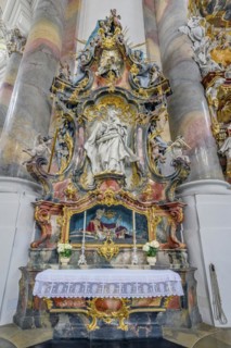 Side altar with floral decoration and saint's relic St. Benedict