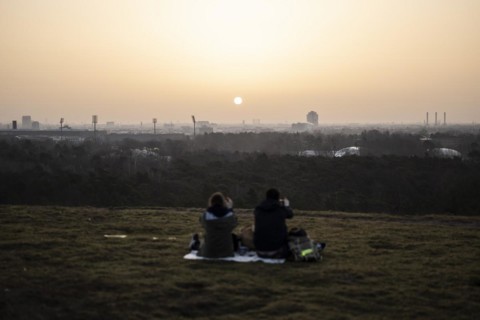 Two people silhouetted against the rising sun in Berlin