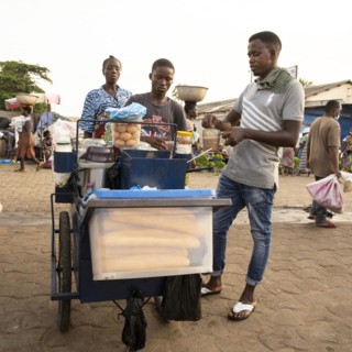 Street vendor selling baguette eggs and coffee at a market in Lome