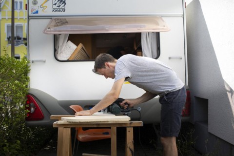 Man tinkering with his caravan.