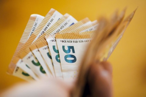 Symbolic photo on the subject of cash. 50 euro banknotes are held in one hand. Berlin