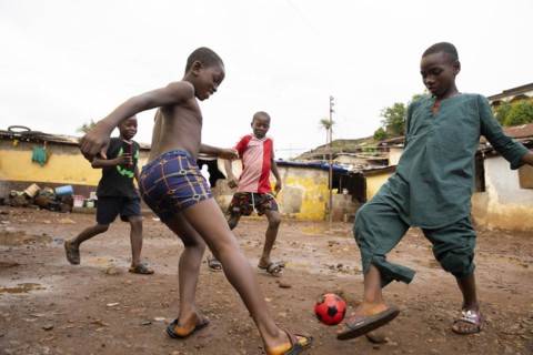Children play football in Bomeh Village at the KissyRoad dumpsite