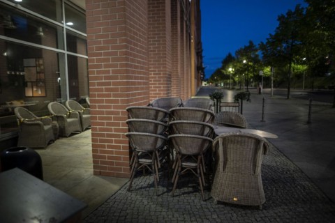 Unused furniture standing in front of a cafe at Potsdamer Platz in Berlin in the evening