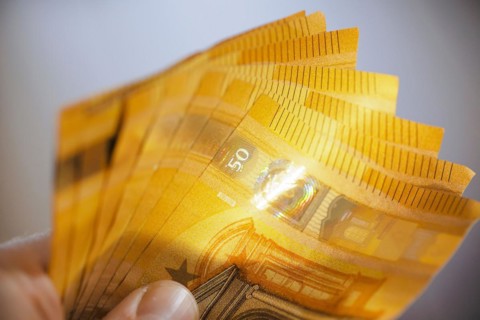 Symbolic photo on the subject of cash. 50 euro banknotes are held in one hand. Berlin