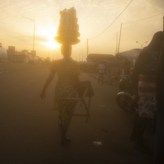 African woman in Togo carries her goods on her head to the market