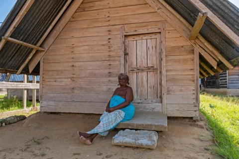 Afro-Surinamese woman posing in front of wooden house in the village Aurora