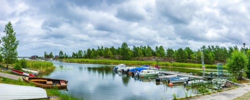 Small boats and picturesque shore landscape at the edge of Lake Vaenern in the area of Sunnana