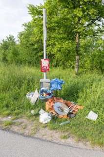 Destroyed rubbish bin with illegally deposited rubbish