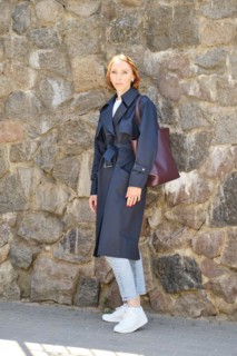 Full length portrait of redhead woman wearing trench coat