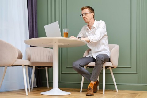 Middle aged man using laptop at home sitting in living room