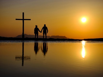 Couple next to summit cross at sunset