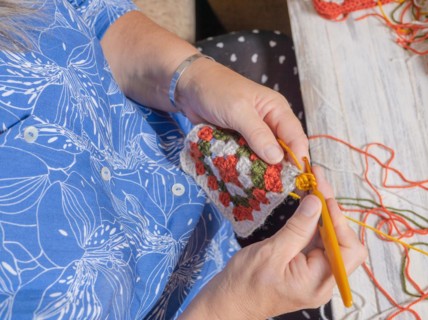 Top close-up view of a woman's crocheting hands