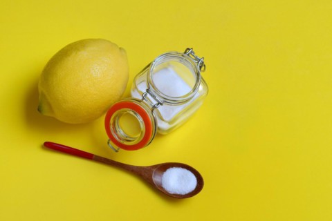 Citric acid in wooden spoon and glass container