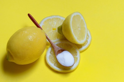 Citric acid in wooden spoon and lemon