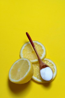 Citric acid in wooden spoon and lemon