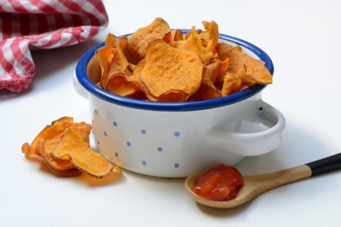 Sweet crisps and salsa sauce in wooden spoon