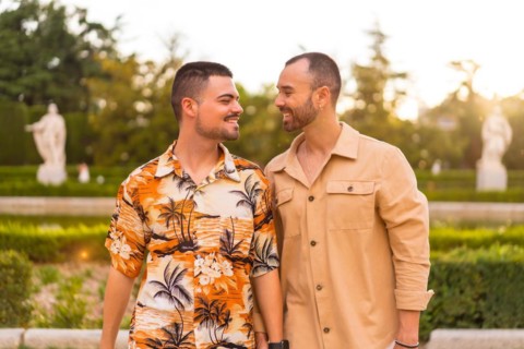 Romantic portrait of gay newlyweds walking in the sunset in a park in the city