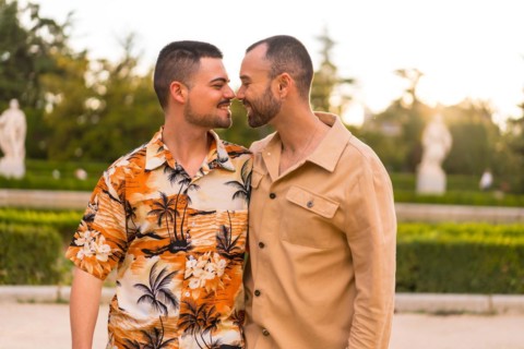 Romantic portrait of gay newlyweds walking and having fun at sunset in a park in the city
