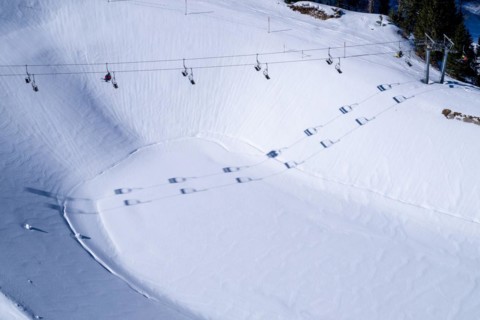 A chairlift casts its shadow over the reservoir in the Brauneck ski area